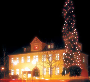 Eine 16m hohe Fichte schmückt weihnachtlich erleuchtet das hundertjährige Rathaus in Kolkwitz