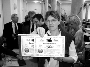 Karin Kühl präsentiert stolz zwei erworbene Parkbahn-AGktien