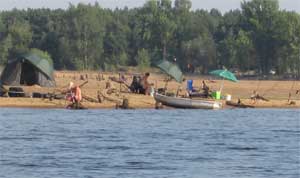 Das Gegenteil von hoch ist dieser Tiefststand, bei dem die Angler und Zelter eigentlich tief im See sitzen. Das Ufer hat sich auf einer Landzunge weit in die sonstige Wassermitte geschoben