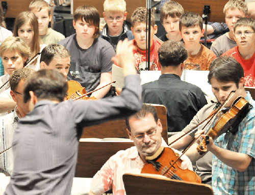 Kinder der Carl-Blechen-Grundschule mitten zwischen den Musikern des Philharmonischen Orchesters. Sie, die Knirpse, sind mit ihren Stimmen als Instrumente besetzt und erleben das Phänomen Musik förmlich mit Haut und Haar. Nach neun Monaten Vorbereitung auf dieses erstaunliche Werk ist morgen die Uraufführung