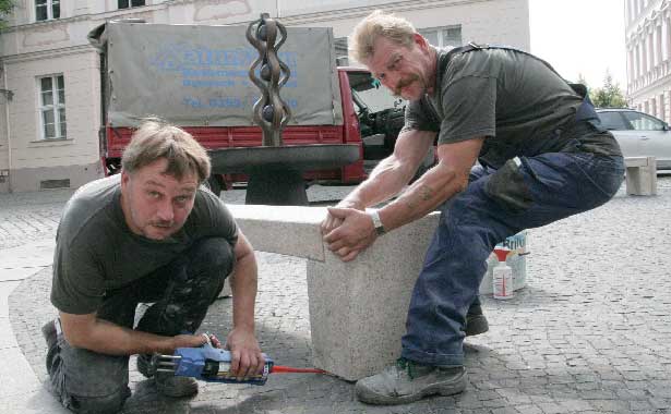 Frank Schultchen (li.) und Frank Noack von der Firma Naturstein Domisch haben am Freitag zwei Granit-Bänke am Neustädter Platz im Auftrag des Bürgervereins Mitte aufgestellt. Wir möchten damit zum Verweilen am Brunnen des Metallgestalters Manfred Vollmert einladen und dabei auch etwas für unsere Altstadt tun, so Hagen Strese, stellvertretender Vorsitzender des Bürgervereins Foto: BeWe