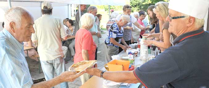 Beliebtes Kuchen- und Plinse-Buffett. Manfred Krokor reicht hier seinem über 80jährigen alten Lehrer Günter Liebscher den Buttermilchplinz „nach geheimem Rezept“