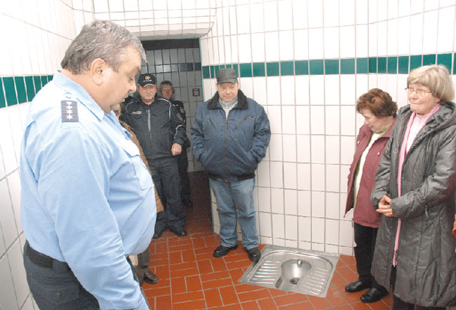 Einen skeptischen Blick auf die Toilette in der Gefängniszelle des Spremberger Reviers werfen die ver.di Senioren am Dienstag. Vom Revierleiter Dietmar Kuschereitz (links) erfuhren sie, dass sich aufgrund der Polizeireform die Wartezeiten, bis ein Polizist am Einsatzort ist, verlängern könnten. Er hatte aber auch eine gute Nachricht: Wurden im Jahr 2004 in Spremberg noch 2871 Straftaten registriert, waren es im vergangenen Jahr nur noch 1823. Gewarnt wurde vor dem Enkeltrick und vor Personen, die mit dem Vorwand ein Glas Wasser zu wollen, sich Zutritt zur Wohnung verschaffen   F: M.K.