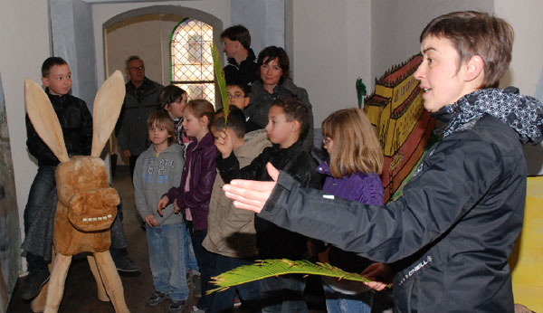 Bild oben: Die Gemeindepä-dagogin Manuela Trummer (r.) heißt mit einem Palmwedel wedelnd einen Schüler aus der Grundschule Mitte in Jerusalem willkommen, der auf dem Esel sitzend, den Jesus spielt