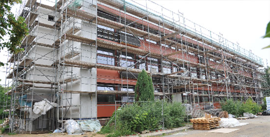 Außenansicht vom Schulhof: Links der Fahrstuhlanbau, unter den Fenstern je Klassenraum eine Klimatruhe  Fotos: J.H.
