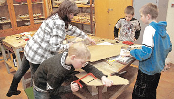 Sich Holzschwerter und Schilde gebastelt haben Jürgen, Evgeny und Daniel (v.l.) im Spremberger Bergschlösschen in den Winterferien. Roswitha Pohl leitete die Kinder an. Andere Bastler bastelten sich auch schon Osterhasen - für die kommenden Ferien 	Foto: M.K.